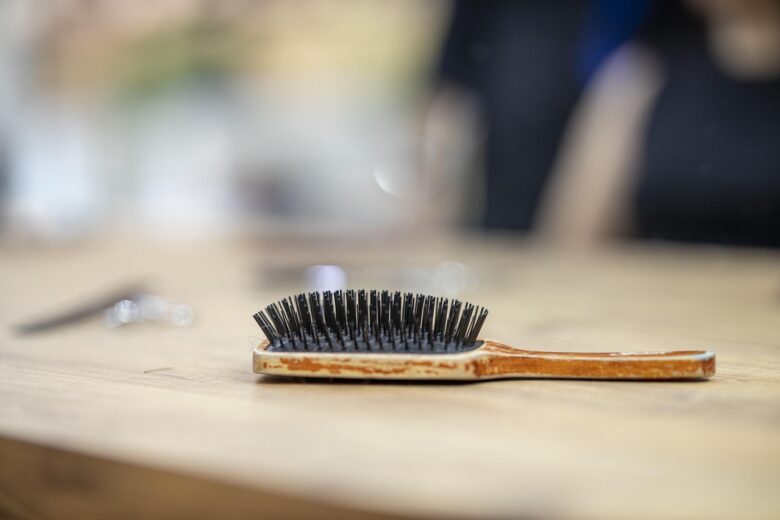 木のテーブルに置かれたヘアブラシ