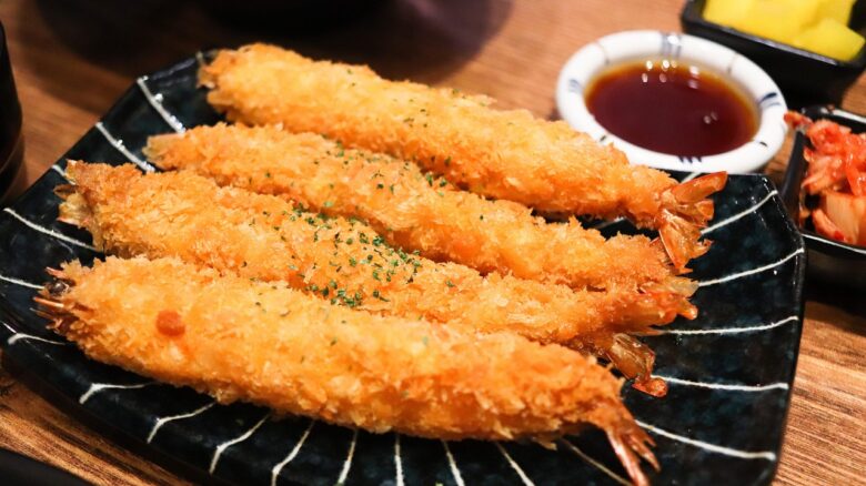 黒い皿に並んだエビフライ